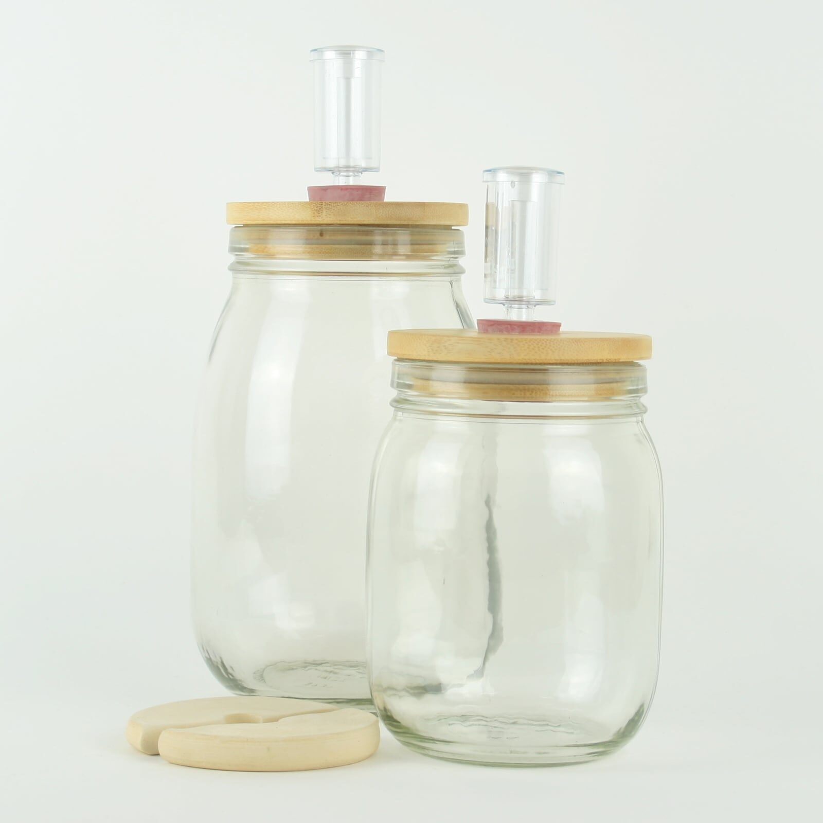 Glass fermentation jar sets with ceramic weights, wooden lids and brewing airlocks. For making sauerkraut and kimchi.