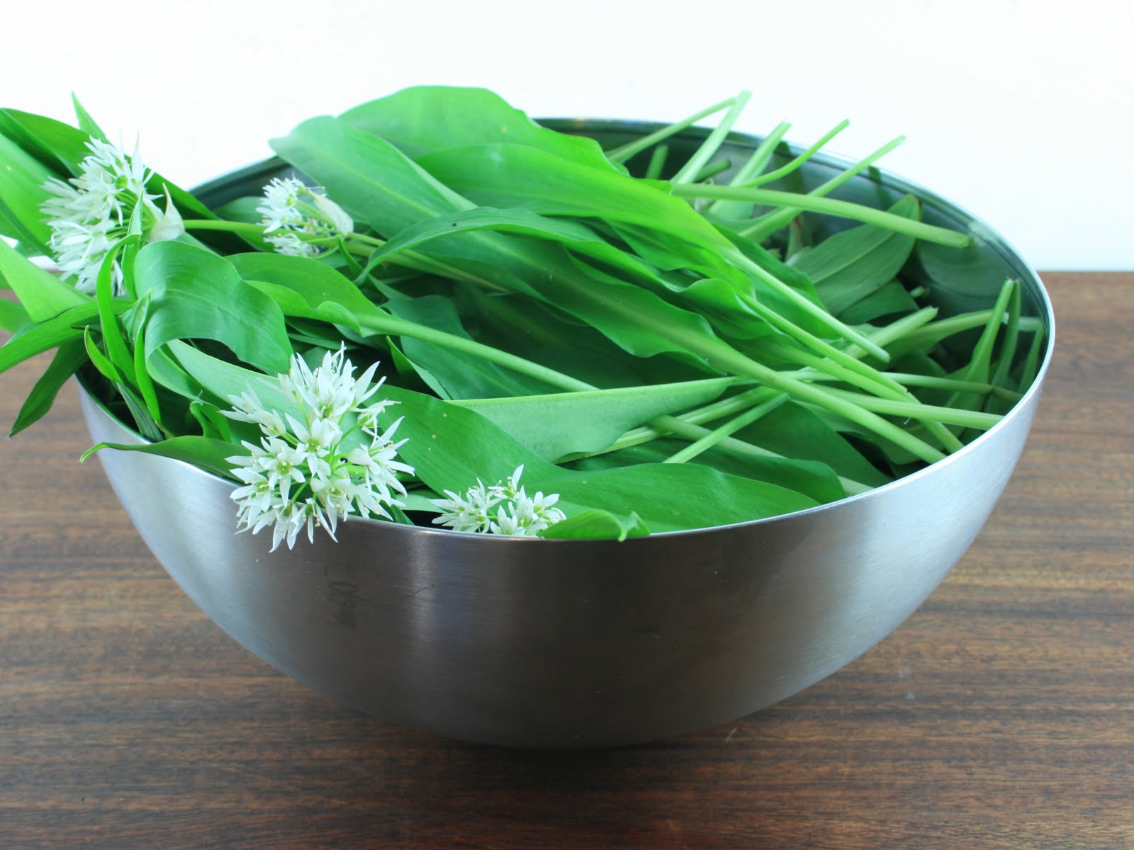 simple wild garlic pesto recipe bowl of allium ursinum flowers and leaves